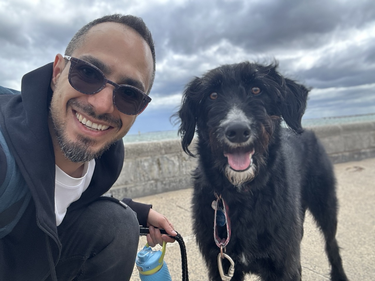 Morty smiling beside Simba on a walk by the sea